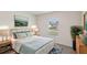 A well-lit staged bedroom with light blue accents, a neutral headboard and two side tables at 15095 Sw 35Th Cir, Ocala, FL 34473
