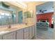 Bright bathroom features double vanity, a large mirror, and a walk-in shower with sliding glass door at 15691 Sw 11Th Court Rd, Ocala, FL 34473