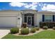 Well-kept single-story home featuring a screened front entry and manicured landscaping at 15691 Sw 11Th Court Rd, Ocala, FL 34473
