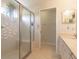 Bright main bathroom featuring a glass-enclosed shower, double sinks, and tile flooring at 15691 Sw 11Th Court Rd, Ocala, FL 34473