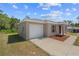 Exterior view of a modern home with a white garage door, neutral siding, and tidy landscaping at 17147 Sw 42Nd Ct, Ocala, FL 34473