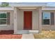 Inviting front entrance featuring a red door, neutral siding, and charming window shutters at 17147 Sw 42Nd Ct, Ocala, FL 34473