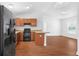 Open kitchen with modern appliances, wood cabinets, and breakfast bar counter at 17147 Sw 42Nd Ct, Ocala, FL 34473