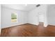 Unfurnished living room with wood floors, white walls, and ample natural light from a window at 17147 Sw 42Nd Ct, Ocala, FL 34473