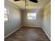 Simple bedroom featuring wood-look flooring, a ceiling fan, and natural light at 21135 Sw Honeysuckle St, Dunnellon, FL 34431