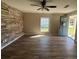 Living room featuring wood floors, stone accent wall, and an exterior door at 21135 Sw Honeysuckle St, Dunnellon, FL 34431