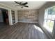 Inviting living room featuring wood floors, a stone accent wall, and natural light at 21135 Sw Honeysuckle St, Dunnellon, FL 34431
