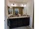Bathroom showcases a double sink vanity, granite countertop and dark wood cabinetry at 3154 Merrit Ln, The Villages, FL 32163