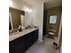Bathroom features double sink vanity with granite counters and dark wood cabinets at 3154 Merrit Ln, The Villages, FL 32163