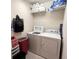 Functional laundry room with washer, dryer, and overhead shelving for storage at 3154 Merrit Ln, The Villages, FL 32163
