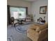 Elegant living room with large windows, offering natural light and a cozy seating arrangement at 3154 Merrit Ln, The Villages, FL 32163