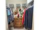Walk-in closet with hanging racks, shelving and wooden dresser for storage at 3154 Merrit Ln, The Villages, FL 32163