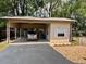 A spacious carport featuring a car, an adjacent storage area, and manicured gravel landscaping at 4145 Se 3Rd St, Ocala, FL 34471