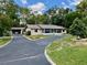 Inviting single-story home featuring a screened-in porch, American flag, and a circular driveway at 4145 Se 3Rd St, Ocala, FL 34471