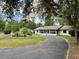 Charming single-story home boasts an extended driveway, lush greenery, and a serene setting at 4145 Se 3Rd St, Ocala, FL 34471