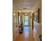 Hallway with hardwood flooring and neutral walls that leads to the front door with lots of light at 4145 Se 3Rd St, Ocala, FL 34471