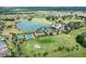 Stunning aerial view showcasing the community's golf course, tennis courts, and a lake with a luxurious pool and clubhouse at 4379 Nw 56Th Ct, Ocala, FL 34482