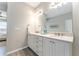 Bathroom featuring double sinks, a large mirror, and modern fixtures with grey tile floor at 4379 Nw 56Th Ct, Ocala, FL 34482
