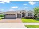 Charming single-story home boasts a three-car garage, arched entryway, and beautifully landscaped front yard at 4379 Nw 56Th Ct, Ocala, FL 34482