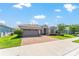 Charming single-story home with a three-car garage, paver driveway and walkway, and lush landscaping on a sunny day at 4379 Nw 56Th Ct, Ocala, FL 34482