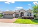 Charming single-story home with a three-car garage, paver driveway and walkway, and lush landscaping at 4379 Nw 56Th Ct, Ocala, FL 34482