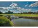 Scenic golf course view showcasing lush greenery, a tranquil pond, and a well-maintained bridge at 4379 Nw 56Th Ct, Ocala, FL 34482