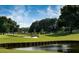 Picturesque golf course showcasing a pristine sand trap and tranquil pond surrounded by mature trees at 4379 Nw 56Th Ct, Ocala, FL 34482