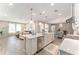 Bright kitchen featuring a center island with pendant lighting, a stainless steel dishwasher and sightlines into the living room at 4379 Nw 56Th Ct, Ocala, FL 34482