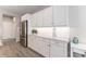 Kitchen featuring all-white cabinetry, stainless steel refrigerator, and light-colored wood floors at 4379 Nw 56Th Ct, Ocala, FL 34482