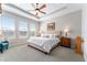 Serene main bedroom with tray ceiling, large windows, and neutral decor with a ceiling fan at 4379 Nw 56Th Ct, Ocala, FL 34482