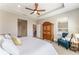 Spacious main bedroom with a tray ceiling, blue chair and armoire at 4379 Nw 56Th Ct, Ocala, FL 34482