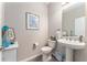 Stylish powder room featuring a pedestal sink, framed artwork, and coastal decor accents at 4379 Nw 56Th Ct, Ocala, FL 34482