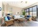 Inviting sunroom boasts stylish seating, wood-look flooring, and ample natural light for relaxing and entertaining at 4379 Nw 56Th Ct, Ocala, FL 34482