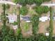 Overhead view of a neighborhood home surrounded by trees and greenery, featuring a pool and large lawn area at 4430 Se 47Th Pl, Ocala, FL 34480