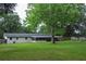 Backyard view featuring the home, screened in patio, and green grass at 4430 Se 47Th Pl, Ocala, FL 34480