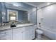 Bathroom with a granite vanity, framed mirror, and tiled bathtub and shower at 4430 Se 47Th Pl, Ocala, FL 34480
