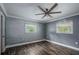Bedroom featuring hardwood floors, two windows, and a modern ceiling fan at 4430 Se 47Th Pl, Ocala, FL 34480