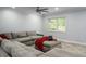 A spacious living room featuring a cozy sectional sofa, ceiling fan, and view of the front yard at 4430 Se 47Th Pl, Ocala, FL 34480