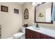 Charming half-bathroom features a decorative mirror, vanity with storage, and elegant wall art at 4530 Nw 78Th Ave, Ocala, FL 34482