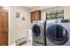 Well-equipped laundry room with modern washer and dryer, wooden cabinets, and functional pet bowls at 4530 Nw 78Th Ave, Ocala, FL 34482