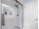 Beautifully tiled walk-in shower with glass door and built-in shelving for toiletries and decorative items at 4530 Nw 78Th Ave, Ocala, FL 34482