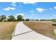 Long paved driveway leading to a home with mature trees in the distance at 5489 Nantahala Ln, Lady Lake, FL 32159
