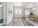 Welcoming entryway featuring decorative glass doors, modern light fixture and stylish gray wood flooring at 5489 Nantahala Ln, Lady Lake, FL 32159