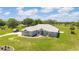 Beautiful single-story home featuring a well-manicured lawn, stylish stone accents and a welcoming, turquoise front door at 5489 Nantahala Ln, Lady Lake, FL 32159