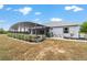 Home exterior featuring a large screened in pool and well maintained lawn at 5489 Nantahala Ln, Lady Lake, FL 32159
