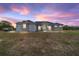 Charming single-story home featuring a stucco exterior, stone accents with a colorful dusk sky at 5489 Nantahala Ln, Lady Lake, FL 32159