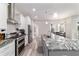 Gourmet kitchen with large island, stainless steel appliances, and gray wood flooring at 5489 Nantahala Ln, Lady Lake, FL 32159