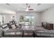 Spacious living room with sliding glass doors opening to the outdoor area and an oversized leather couch at 5489 Nantahala Ln, Lady Lake, FL 32159