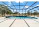 A luxurious pool with waterfall and spa surrounded by a screened enclosure at 5489 Nantahala Ln, Lady Lake, FL 32159
