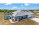 Aerial view featuring a large pool, 3-car garage and lush surroundings at 5489 Nantahala Ln, Lady Lake, FL 32159